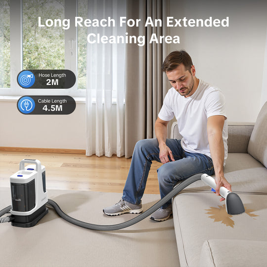 Person using a cleaning device with extended hose and cable in a living room.