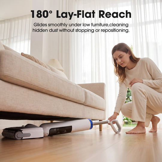 Woman using a vacuum cleaner with '180¡ã Lay-Flat Reach' feature under a couch.