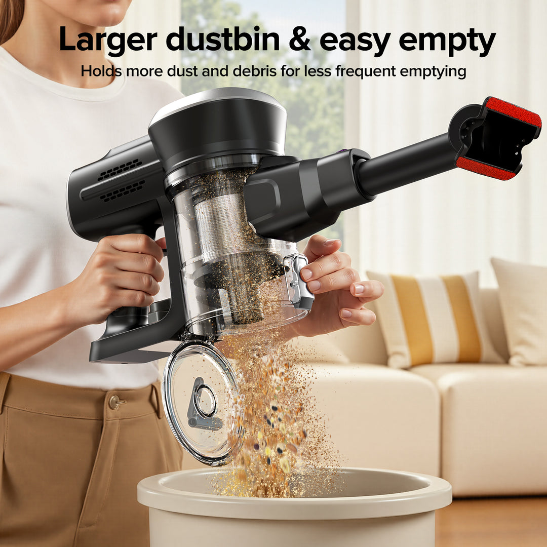 Person using a handheld vacuum cleaner to empty debris into a trash bin in a living room.