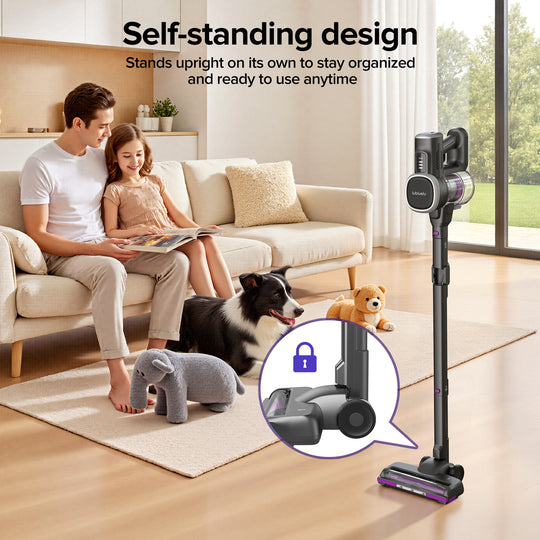 Couple with a dog and teddy bear in a living room with a self-standing vacuum cleaner.