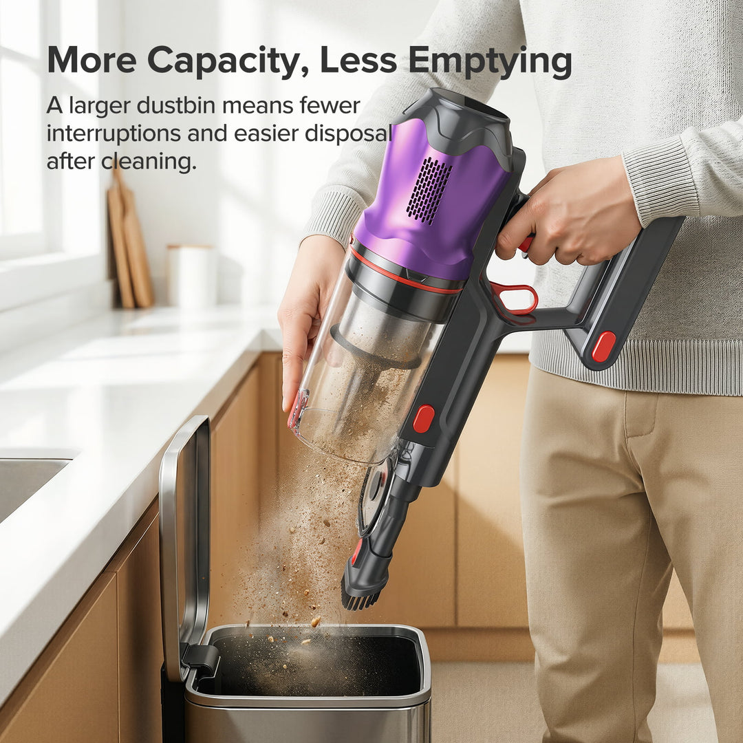 Person using a handheld vacuum cleaner to empty its dustbin into a trash can in a kitchen.