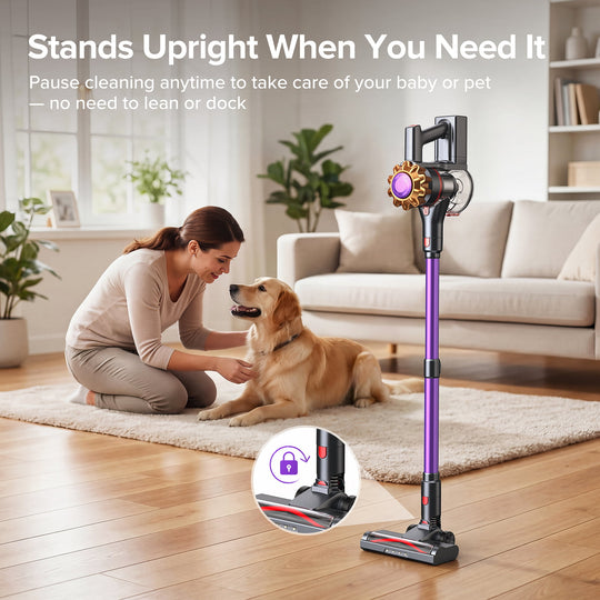 A cordless stick vacuum cleaner with a purple and black body stands on a wooden floor in a bright living room next to a woman kneeling on a rug with a golden retriever. Text at the top reads 'Stands Upright When You Need It' and there is a circular inset showing a lock feature.
