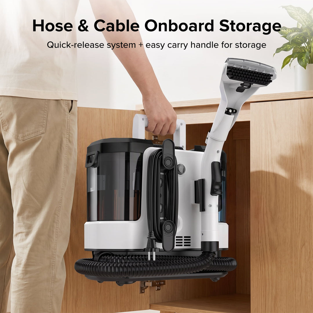 A cordless wet vacuum cleaner with a hose attachment is shown being stored inside a wooden cabinet, with a person's hand holding the handle. The vacuum is white and black, and the cabinet is light wood.